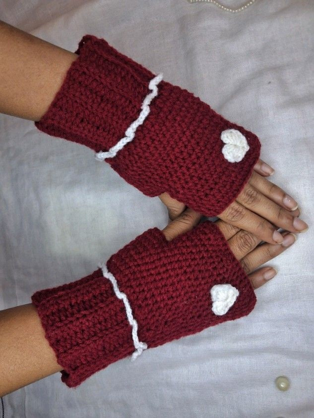 Red hand warmers with white heart and white outline